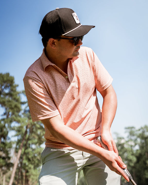 Men’s Phoenix Whirl golf polo by Pins & Aces featuring a bold swirling colorful print, modern blade collar, short sleeves, and athletic performance fit.