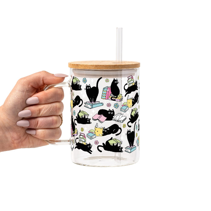 Black Cats on Books drinkware design featuring whimsical black cats lounging on colorful stacks of books with pastel flowers and bookish details.