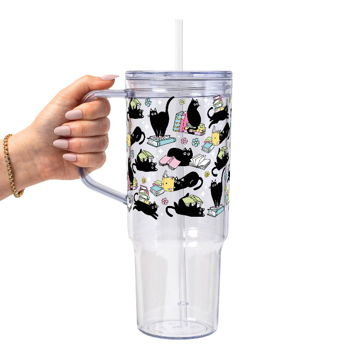 Black Cats on Books drinkware design featuring whimsical black cats lounging on colorful stacks of books with pastel flowers and bookish details.