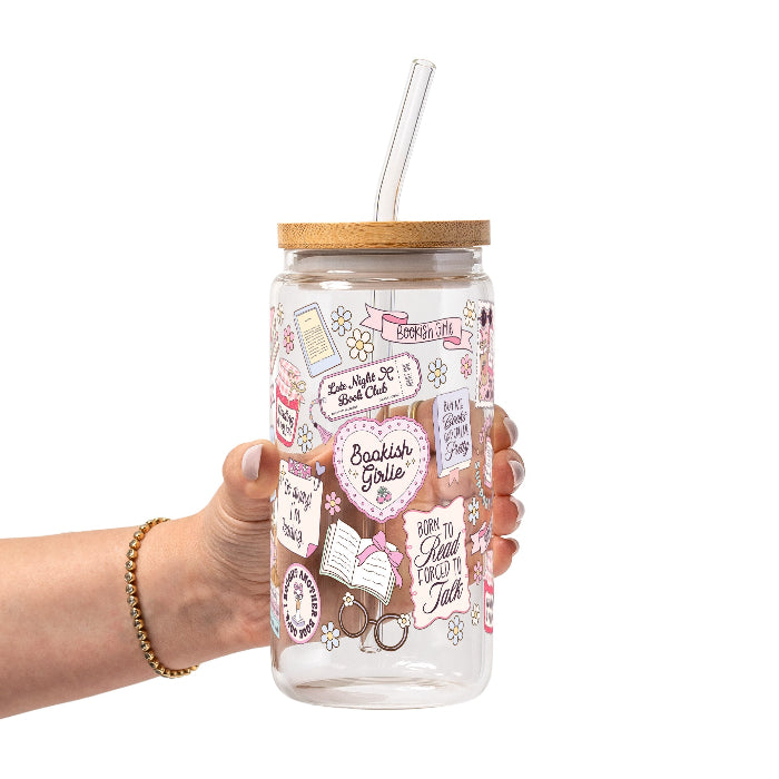 Clear glass cup with bamboo lid and straw featuring a pink pastel bookish collage with books, flowers, reading glasses, hearts and feminine reader-themed sayings.