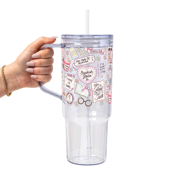 Clear tumbler with colorful designs held by a hand on a white background