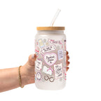 Clear glass cup with bamboo lid and straw featuring a pink pastel bookish collage with books, flowers, reading glasses, hearts and feminine reader-themed sayings.