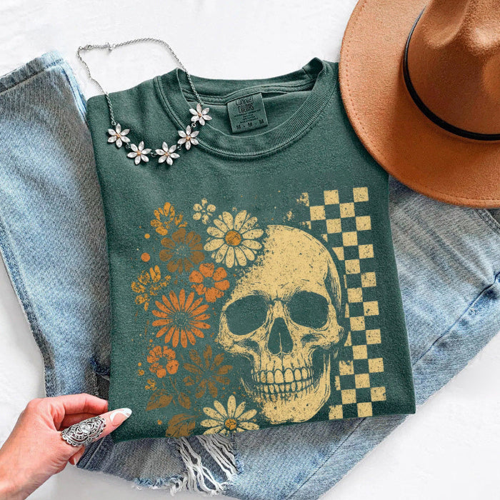 Skull and Flowers Firefly Comfort Colors T-shirt featuring a detailed skull surrounded by blooming flowers and glowing fireflies in a Halloween-inspired graphic design in Blue Spruce