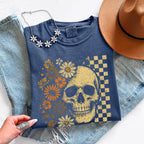 Skull and Flowers Firefly Comfort Colors T-shirt featuring a detailed skull surrounded by blooming flowers and glowing fireflies in a Halloween-inspired graphic design in Denim