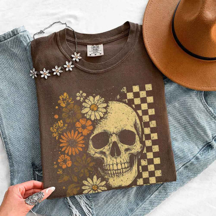 Skull and Flowers Firefly Comfort Colors T-shirt featuring a detailed skull surrounded by blooming flowers and glowing fireflies in a Halloween-inspired graphic design in Espresso