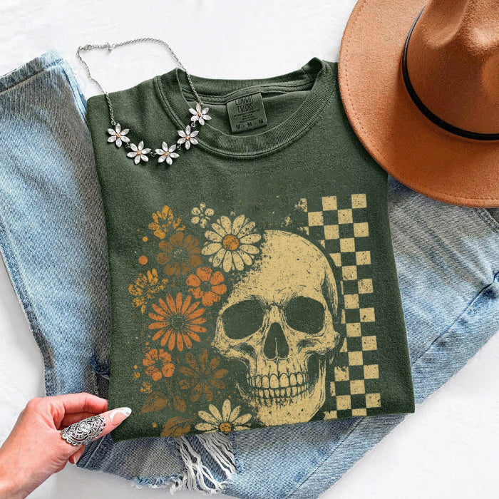 Skull and Flowers Firefly Comfort Colors T-shirt featuring a detailed skull surrounded by blooming flowers and glowing fireflies in a Halloween-inspired graphic design in Moss