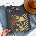 Skull and Flowers Firefly Comfort Colors T-shirt featuring a detailed skull surrounded by blooming flowers and glowing fireflies in a Halloween-inspired graphic design in Pepper