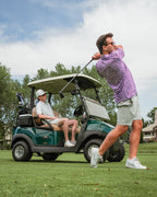 Men’s Sugar Circuit golf polo by Pins & Aces featuring a vibrant pink, purple, and blue geometric all-over pattern with short sleeves and an athletic performance fit.
