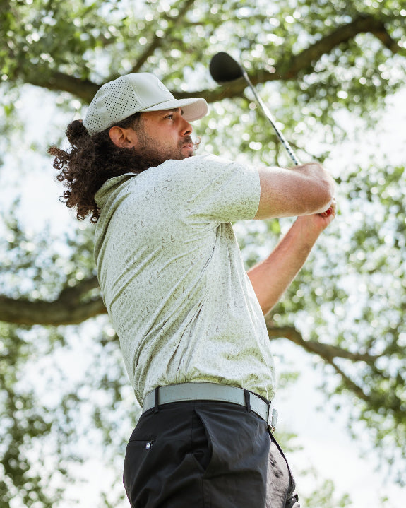 Men’s Drinking Buddies golf polo by Pins & Aces featuring a subtle drinking-inspired all-over print on a cream short-sleeve performance polo with an athletic fit.