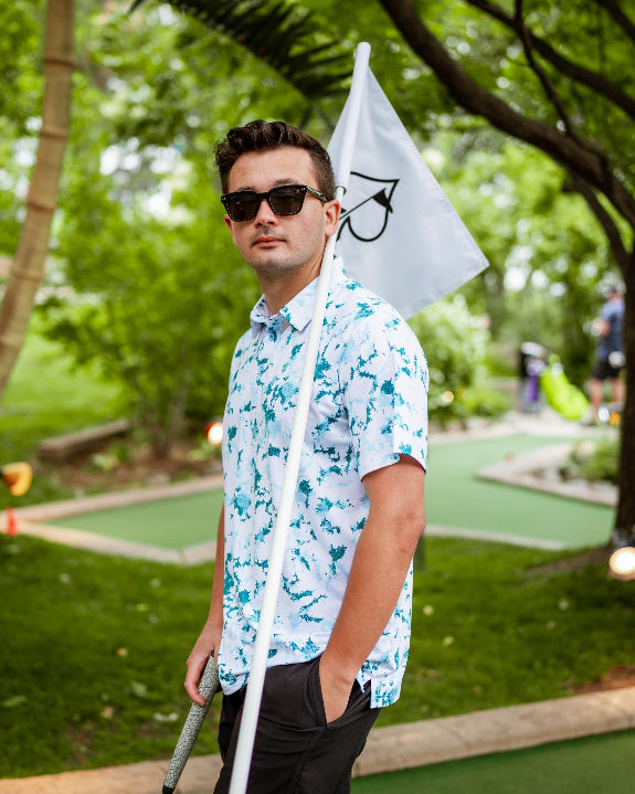Men’s Frost Burn blue performance golf polo by Pins & Aces featuring a cool-toned design, short sleeves, collared neckline, and athletic fit.