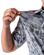 Men’s Arctic Ops golf polo by Pins & Aces featuring an all-over gray, silver, and black camouflage print with short sleeves, collared neckline, and athletic performance fit.