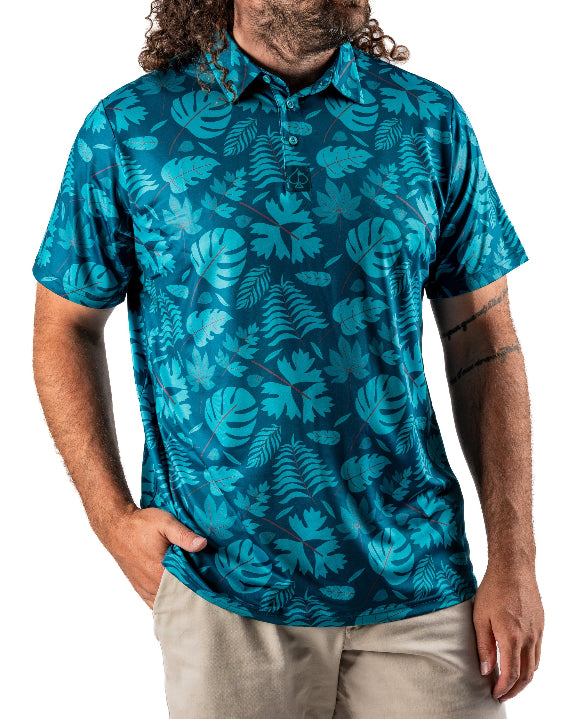 Men’s Cabana Nights golf polo by Pins & Aces featuring a blue and teal tropical leaf print, short sleeves, and athletic performance fit.