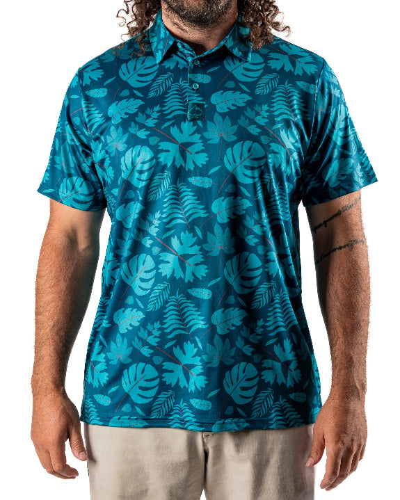 Men’s Cabana Nights golf polo by Pins & Aces featuring a blue and teal tropical leaf print, short sleeves, and athletic performance fit.