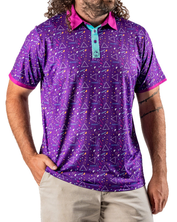 Men’s Eighties Arcade golf polo by Pins & Aces featuring a purple retro geometric print with pink and teal accents, short sleeves, and an athletic performance fit.