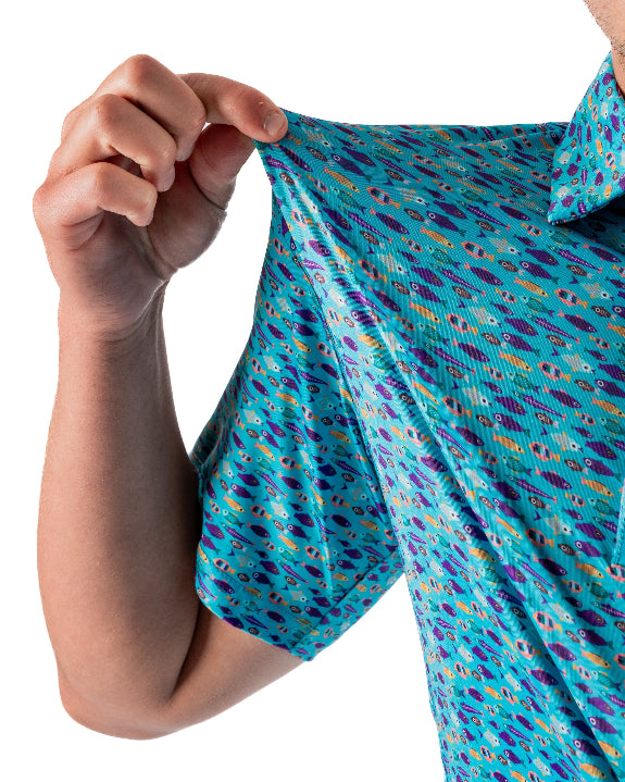 Men’s Fish & Drips golf polo by Pins & Aces featuring a bright aqua blue all-over fish print with colorful fishing-inspired details, short sleeves, and an athletic performance fit.