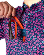 Men’s Full Bloom golf polo by Pins & Aces featuring an all-over bright pink floral pattern on a navy background with short sleeves and an athletic performance fit.