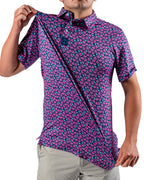 Men’s Full Bloom golf polo by Pins & Aces featuring an all-over bright pink floral pattern on a navy background with short sleeves and an athletic performance fit.