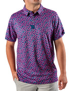 Men’s Full Bloom golf polo by Pins & Aces featuring an all-over bright pink floral pattern on a navy background with short sleeves and an athletic performance fit.