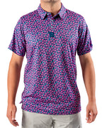 Men’s Full Bloom golf polo by Pins & Aces featuring an all-over bright pink floral pattern on a navy background with short sleeves and an athletic performance fit.
