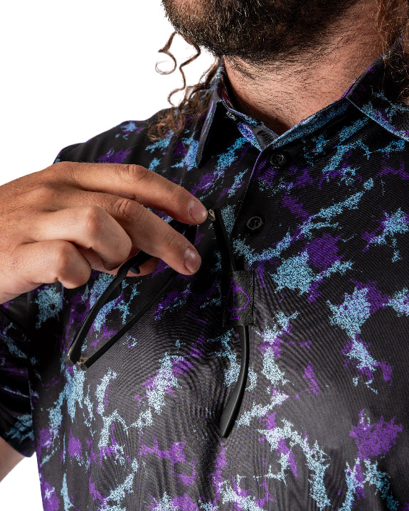Men’s Moon Burn golf polo by Pins & Aces featuring an abstract purple, blue, and black cosmic-inspired pattern with short sleeves and an athletic performance fit.