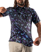 Men’s Moon Burn golf polo by Pins & Aces featuring an abstract purple, blue, and black cosmic-inspired pattern with short sleeves and an athletic performance fit.