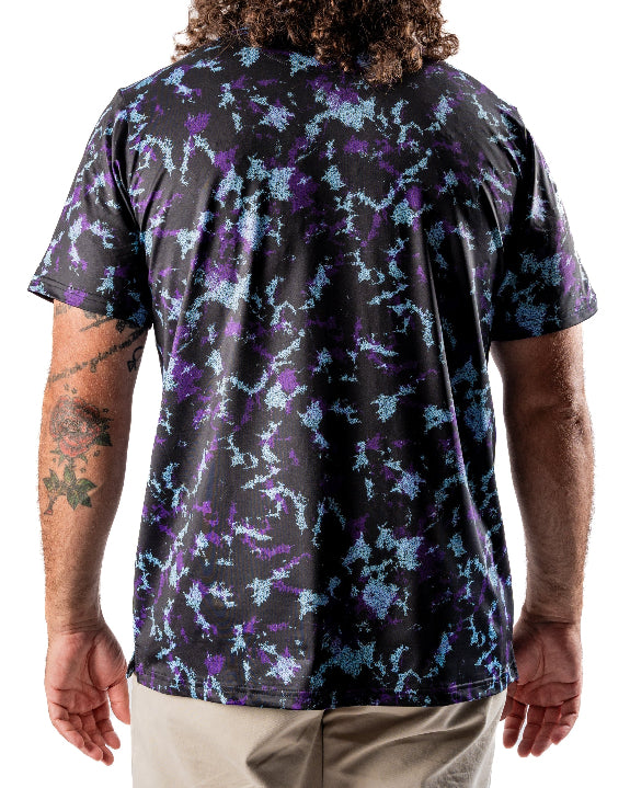 Men’s Moon Burn golf polo by Pins & Aces featuring an abstract purple, blue, and black cosmic-inspired pattern with short sleeves and an athletic performance fit.