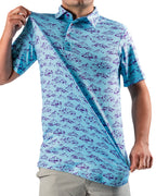 Men’s Purple Majesty golf polo by Pins & Aces featuring an aqua blue base with an all-over purple illustrated mountain print, short sleeves, and athletic performance fit.