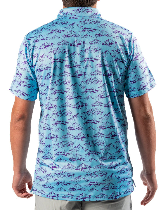 Men’s Purple Majesty golf polo by Pins & Aces featuring an aqua blue base with an all-over purple illustrated mountain print, short sleeves, and athletic performance fit.