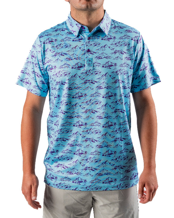 Men’s Purple Majesty golf polo by Pins & Aces featuring an aqua blue base with an all-over purple illustrated mountain print, short sleeves, and athletic performance fit.