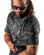 Men’s Shadow Ops black camo golf polo by Pins & Aces featuring a tonal black and charcoal camouflage pattern, short sleeves, collared neckline, and athletic fit.