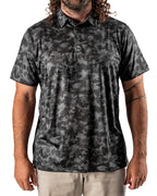 Men’s Shadow Ops black camo golf polo by Pins & Aces featuring a tonal black and charcoal camouflage pattern, short sleeves, collared neckline, and athletic fit.
