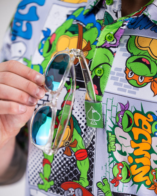 Men’s TMNT Comic Strip golf polo by Pins & Aces featuring colorful Teenage Mutant Ninja Turtles comic artwork in an all-over print.