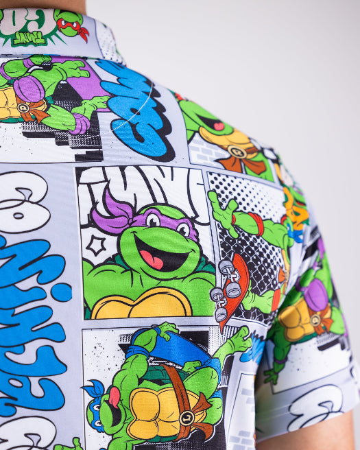 Men’s TMNT Comic Strip golf polo by Pins & Aces featuring colorful Teenage Mutant Ninja Turtles comic artwork in an all-over print.