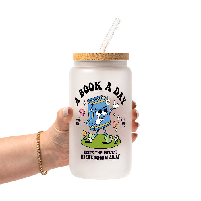 White mug featuring a colorful retro walking book character with flowers and a rainbow, “A Book A Day” lettering, “Read More Cry Less,” and “Keeps the Mental Breakdown Away” text.