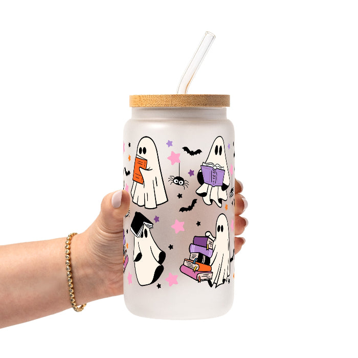 Ghosts and Books drinkware design featuring cute white ghosts reading and carrying colorful books surrounded by black bats and pink, purple and orange stars.
