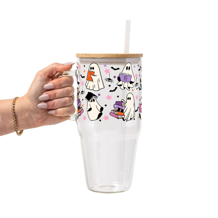 Ghosts and Books drinkware design featuring cute white ghosts reading and carrying colorful books surrounded by black bats and pink, purple and orange stars.