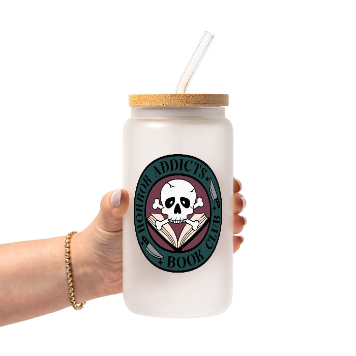 Horror Addicts Book Club design featuring a white skull and crossbones over an open book with knife illustrations, gothic black lettering, and a deep teal and burgundy circular background.