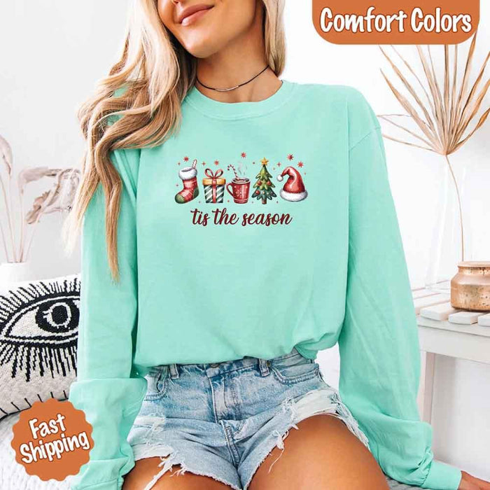 ’Tis The Season Comfort Colors long sleeve Christmas shirt featuring a festive holiday graphic on a soft garment-dyed 100% cotton tee in Light Green