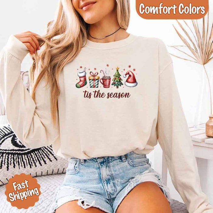 ’Tis The Season Comfort Colors long sleeve Christmas shirt featuring a festive holiday graphic on a soft garment-dyed 100% cotton tee in Ivory