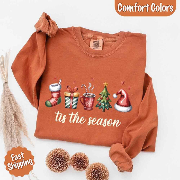 ’Tis The Season Comfort Colors long sleeve Christmas shirt featuring a festive holiday graphic on a soft garment-dyed 100% cotton tee in Yam