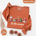 ’Tis The Season Comfort Colors long sleeve Christmas shirt featuring a festive holiday graphic on a soft garment-dyed 100% cotton tee in Yam