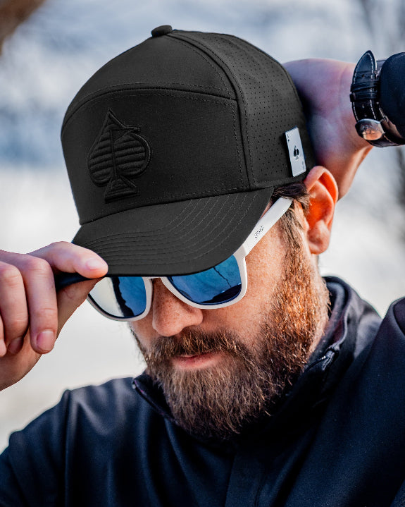 Tradesman Black golf hat by Pins & Aces featuring structured 6-panel construction, adjustable snapback closure, and a built-in magnetic golf ball marker holder.