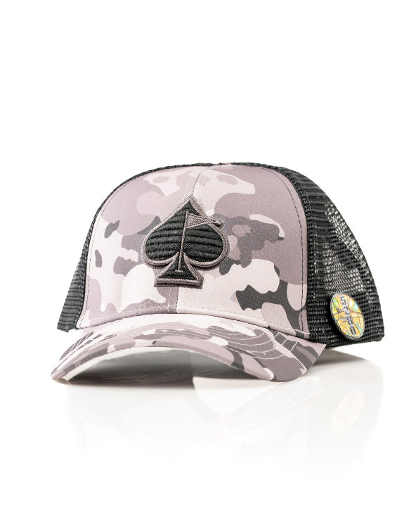 Urban Camo trucker golf hat by Pins & Aces featuring a gray, black, and white camouflage print, embroidered black spade logo, black mesh back, curved bill, and snapback design.