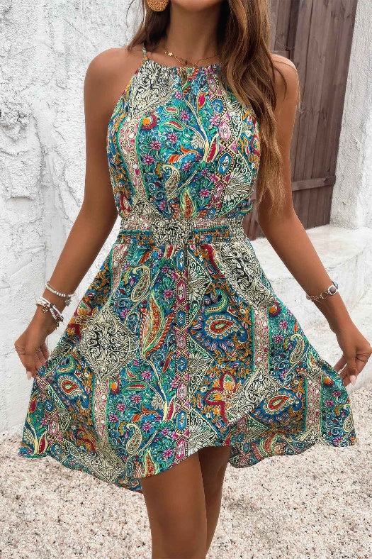 Women’s sleeveless paisley print dress featuring a flattering halter neckline, lightweight fabric, relaxed silhouette, and feminine bohemian-inspired design.