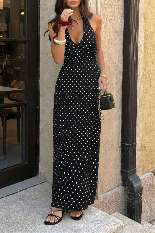 Women’s polka dot halter maxi dress featuring a sleeveless neckline, fitted bodycon silhouette, timeless polka dot print, and elegant long-length design in black.