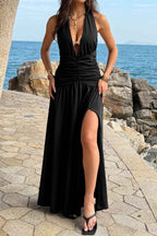 Women’s halter deep V-neck maxi dress featuring flattering ruched detailing, a dramatic high side slit, and an elegant figure-enhancing silhouette.