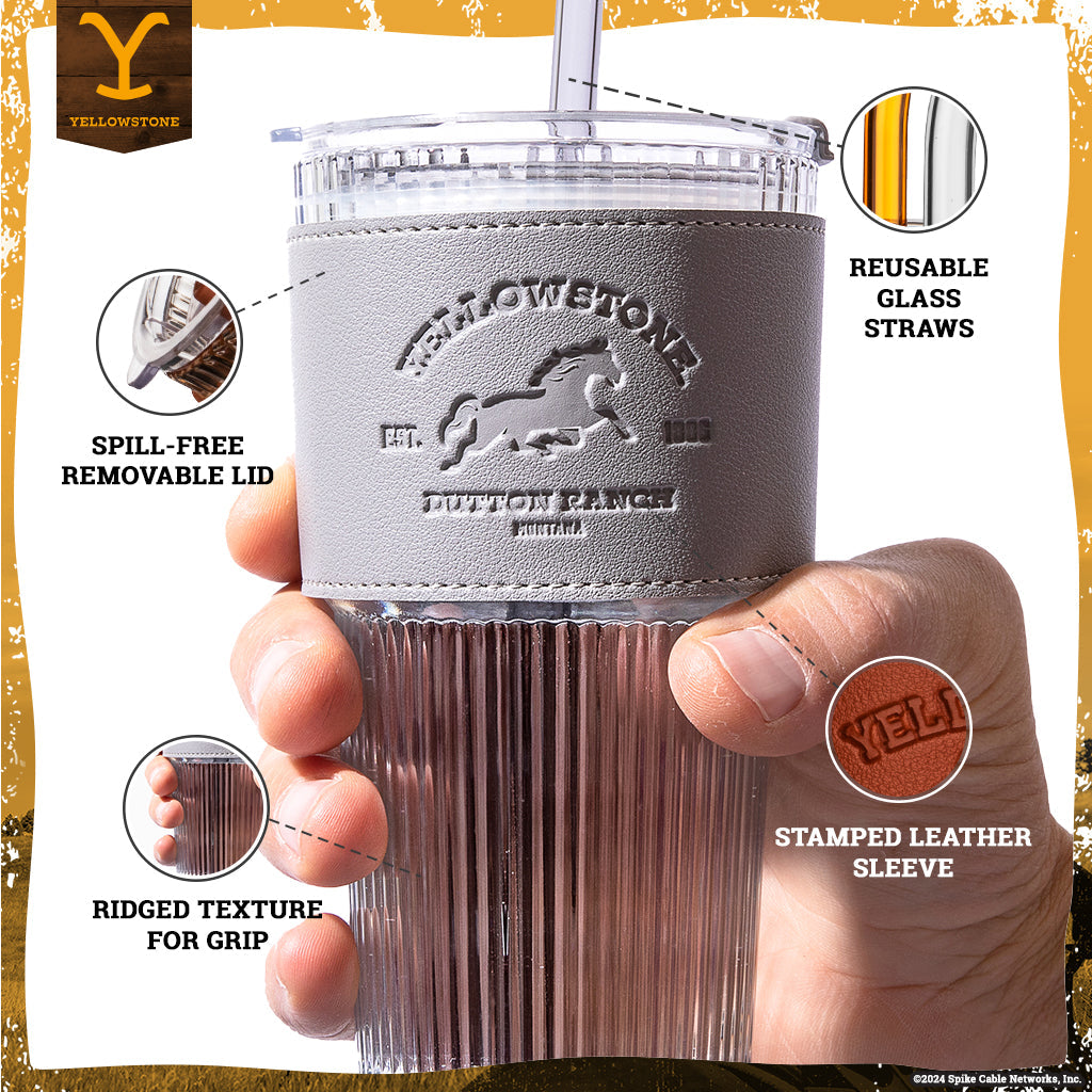 Set of two officially licensed Yellowstone 20-ounce glass drinking tumblers featuring Western-inspired designs with reusable lids and straws.