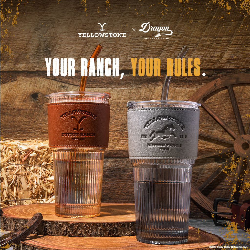 Set of two officially licensed Yellowstone 20-ounce glass drinking tumblers featuring Western-inspired designs with reusable lids and straws.