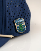 Zynbabwe Country Club Navy perforated rope golf hat by Pins & Aces with adjustable snapback, magnetic ball marker holder, and matching golf ball marker.
