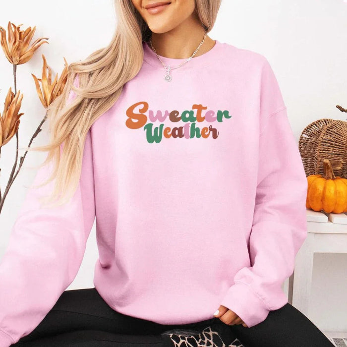 Sweater Weather Fall Vibes unisex crewneck sweatshirt featuring a cozy autumn-inspired graphic design for fall in Pink.